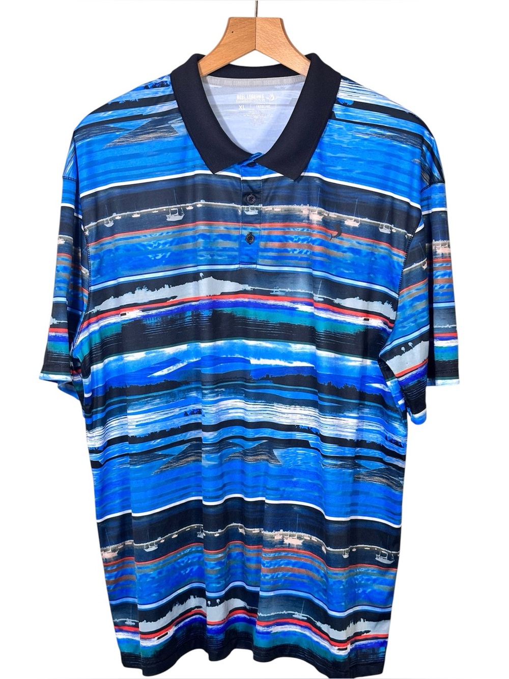 Reel Legends polo shirt in a vibrant, multi-tonal blue landscape print. Men’s XL